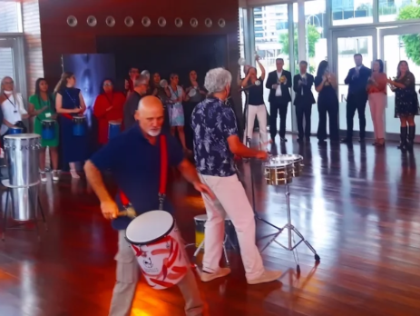 Grupo de colaboradores de una empresa participando activamente en una dinámica de team building de percusión en Argentina.