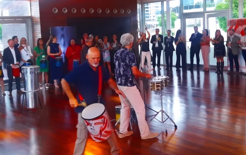 Grupo de colaboradores de una empresa participando activamente en una dinámica de team building de percusión en Argentina.