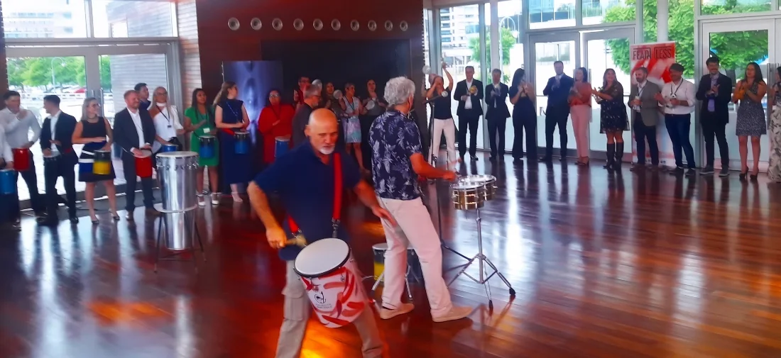 Grupo de colaboradores de una empresa participando activamente en una dinámica de team building de percusión en Argentina.