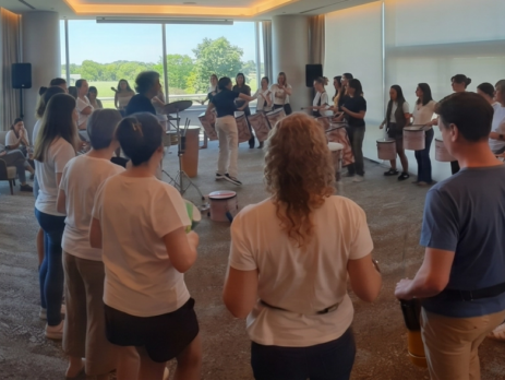 Facilitador guiando un círculo de percusión dinámico con participantes de una empresa en Buenos Aires.