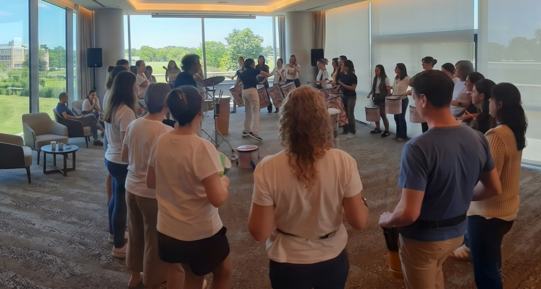 Facilitador guiando un círculo de percusión dinámico con participantes de una empresa en Buenos Aires.