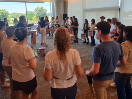 Empleados de una empresa participando activamente en dinámicas y actividades en equipo con instrumentos de percusión en Buenos Aires.