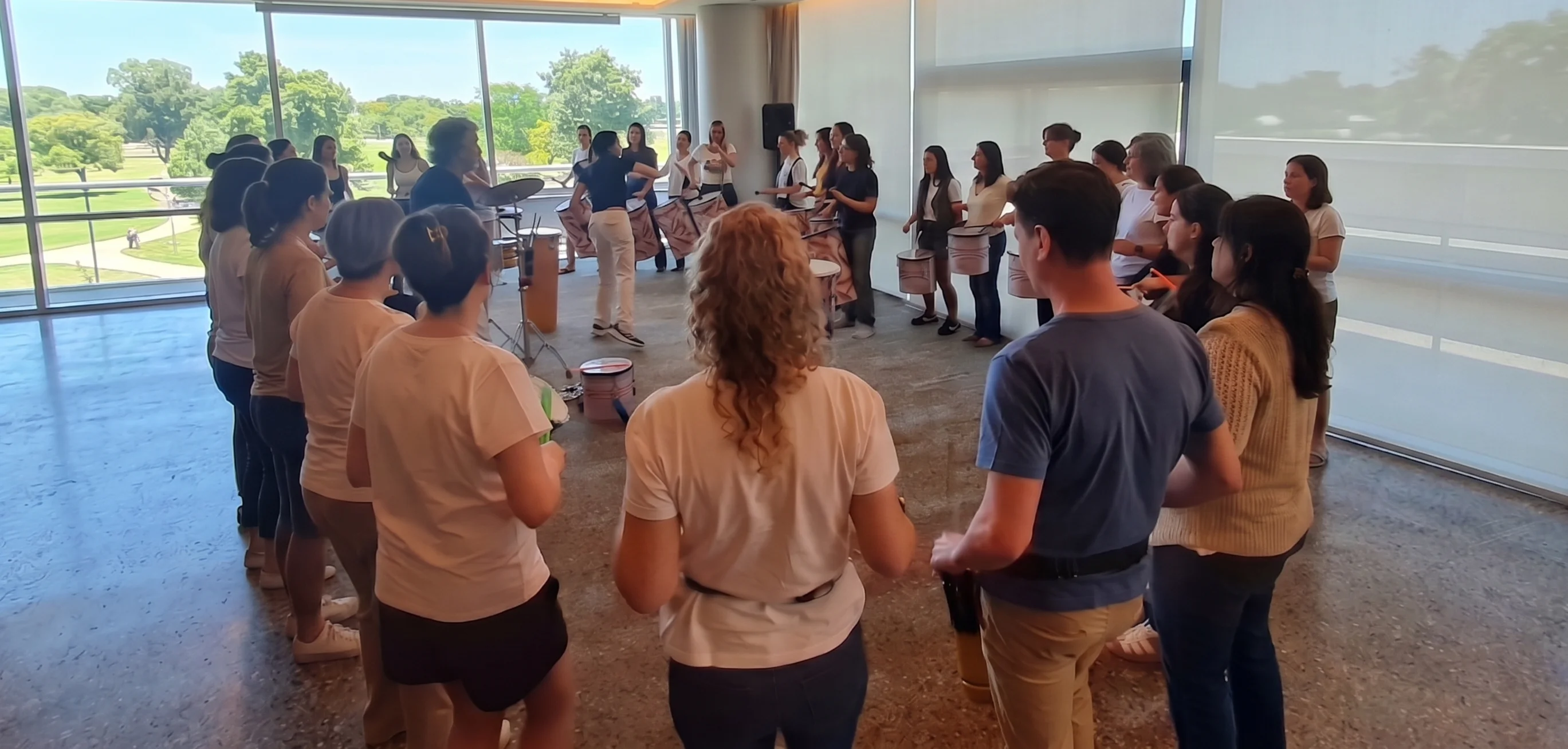 Empleados de una empresa participando activamente en dinámicas y actividades en equipo con instrumentos de percusión en Buenos Aires.