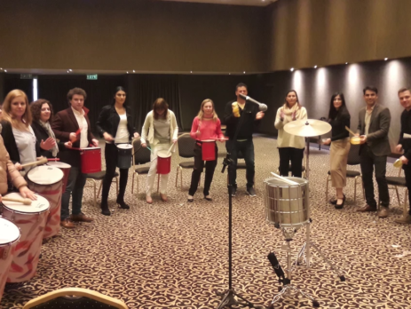 Grupo de personas participando en una dinámica de percusión, una de las mejores ideas para eventos corporativos en Buenos Aires.
