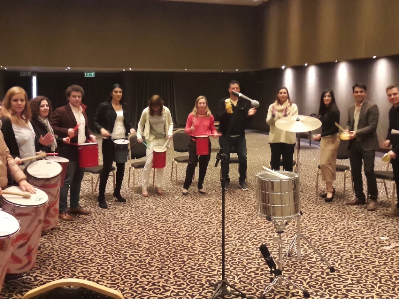 Grupo de personas participando en una dinámica de percusión, una de las mejores ideas para eventos corporativos en Buenos Aires.