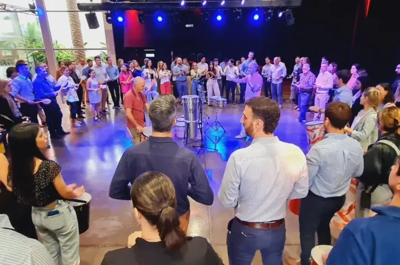 Grupo de colaboradores participando activamente de una jornada de Team Building en Buenos Aires con Círculo de Tambores.