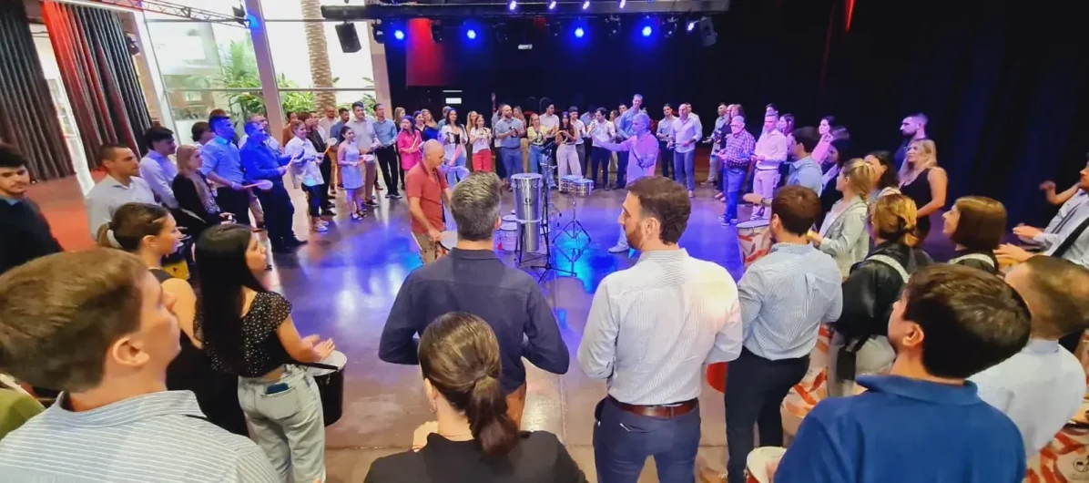 Grupo de colaboradores participando activamente de una jornada de Team Building en Buenos Aires con Círculo de Tambores.