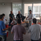 Empleados y líderes colaborando en un círculo de percusión, descubriendo cómo mejorar el clima laboral en una empresa en Argentina.