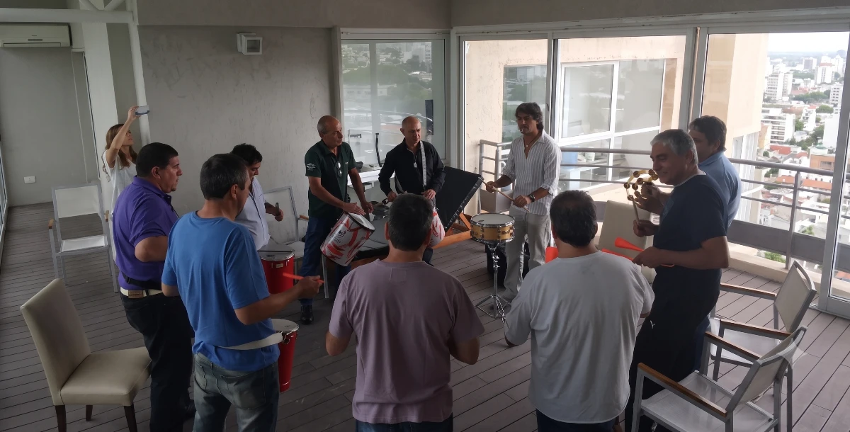 Empleados y líderes colaborando en un círculo de percusión, descubriendo cómo mejorar el clima laboral en una empresa en Argentina.
